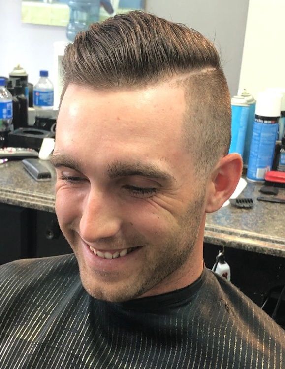 Smiling client with a side-part haircut and hard part line